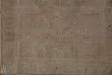 Reverse of a vintage hand-knotted Oushak rug showing visible knotting and small pink marks.