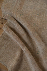 Soft, distressed pile of a vintage Oushak rug in antique ivory and faded teal.