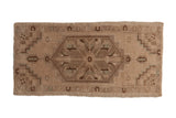 Distressed vintage Oushak rug mat with faded beige and brown geometric floral motifs.