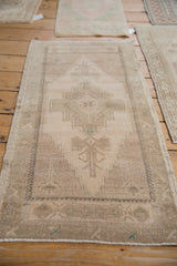 Original side cord selvage and faded, short pile of a distressed Oushak runner.