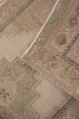 Distressed Oushak rug pile revealing faded blush and teal with original side selvage.