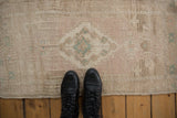 Distressed short pile of a vintage Oushak rug with blush and seafoam accents, shown to scale.