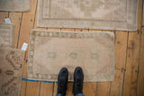 Distressed vintage Oushak mat, worn texture, faded blush, teal, and ivory motifs.