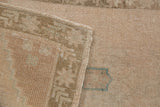 Distressed vintage Oushak rug with faded pile, intact selvage, and woven foundation featuring a teal accent.
