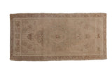 Faded vintage Oushak rug runner, ivory field with subtle medallion and floral designs.
