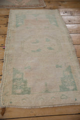 Faded floral patterns on a distressed Turkish Oushak rug with intact side selvage.