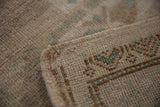 Distressed Oushak rug with even worn pile and intact side cord selvage.