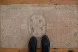 Distressed vintage Oushak rug mat, muted mauve and jade green with even wear.