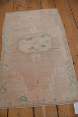 Distressed Oushak rug pile with subtle jade green motifs and even wear to knot heads.