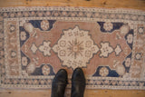 Distressed Oushak rug border featuring pale dusty navy, coffee brown, and oxidized silver motifs.