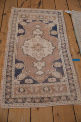 Distressed Oushak runner end, with intact fringe and pale coffee brown, navy blue border.