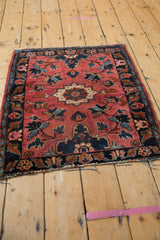 Vintage Lilihan rug corner shows navy floral border and raspberry field with gentle patina.
