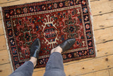 Traditional geometric Karaja rug with central hook medallion and floral pinwheel designs.