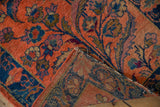 Folded corner of a vintage Lilihan rug, revealing its woven foundation and tattered dusty blush selvage.