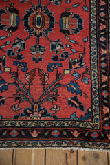 Vintage Lilihan rug, fringed bottom showing red, navy floral border with blossoming vines.