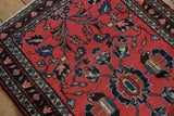 Vintage Lilihan rug's central floral medallion with pomegranate contour and bursting buds on a red field.