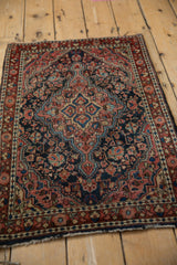 Tattered end of the vintage Josan Sarouk rug, with dusty raspberry floral border.