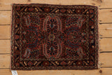 Tattered fringe and navy border with dusty raspberry floral motifs on vintage Josan Sarouk.
