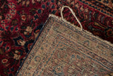 Hand-knotted foundation, secure navy selvage, and cherry red floral pile of the Sarouk rug.