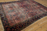 Visible worn texture and tattered edge of a traditional Lilihan rug in red and navy.