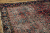 Vintage Lilihan rug detail: cochineal red field, navy tree-of-life floral motifs, and visible foundation wear.