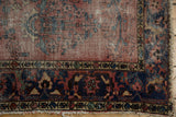Tattered fringe and worn navy blue border detail on a vintage Lilihan rug.
