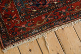 Vintage Kurdish Hamadan rug corner showing light fringe, original plain weave, and red Herati design.