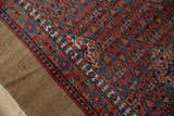 Intricate floral patterns and border on a Vintage Serab rug with camel side.
