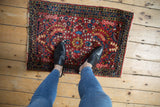 Vintage American Sarouk rug corner, cherry red floral field, indigo meandering vine border.
