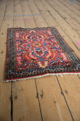 Corner of vintage Sarouk rug with cherry red floral field and indigo blue vine border.
