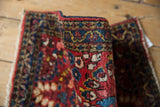 Textured cherry red pile and indigo blue meandering vine border of vintage Sarouk.