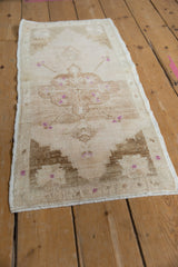 Distressed vintage Oushak rug's side selvage shows worn pile, ivory, brown, and purple finial details.