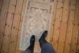 Turkish vintage distressed Oushak rug, central floral medallion, serrated leaves, muted beige and seafoam.