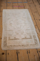 Textured pile of distressed vintage Oushak rug, with muted beige and sand border.