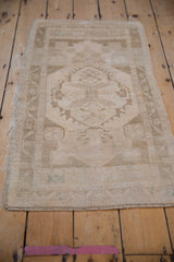 Distressed texture and faded floral border of a vintage Oushak rug with original end selvage.