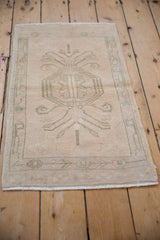 Distressed texture, faded dusty sage floral design, and even wear on vintage Oushak rug.