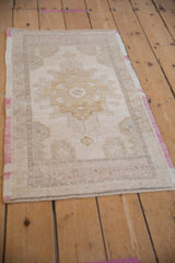 Faded raspberry selvage and soft geometric motifs on a distressed Oushak rug.