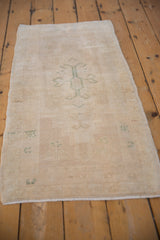 Distressed ivory and sand Oushak runner with even wear and subtle seafoam patterns.