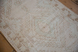 Distressed Oushak runner showing faded cream, seafoam, and pale coffee bronze geometric motifs.