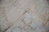 Distressed vintage Oushak rug corner showing worn cream pile and hand-knotted back.