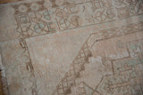 Distressed Oushak rug texture with geometric field motifs in cream and muted blue.