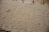 Textured, distressed Oushak rug pile with subtle abrashes and faint cream, teal patterns.
