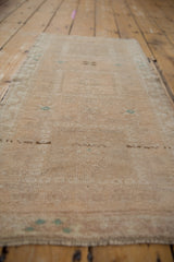 Decorative distressed texture of a vintage Oushak rug, showing even wear and beige abrashes with subtle green.