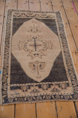 Distressed Oushak rug corner showing time-softened tones, decorative main border, and aged texture.