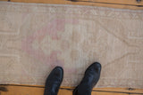 Distressed Oushak rug texture in faded ivory, beige, and dusty pink hues.