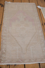Soft dusty pink distressed pile of a vintage Oushak runner with intact side selvage.