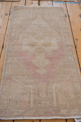 Detail of distressed vintage Oushak rug showing worn texture and faded dusty pink floral design.