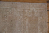 Distressed vintage Oushak rug mat with even wear, subtle geometric patterns, intact selvage.