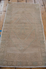 Distressed Oushak rug close-up: intact selvage, soft pile, and faded seafoam geometric pattern.