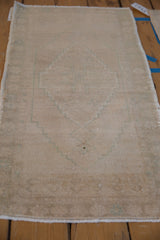Distressed vintage Oushak rug with faint beige and seafoam green geometric patterns.